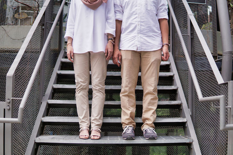 Low section of couple standing on stairs