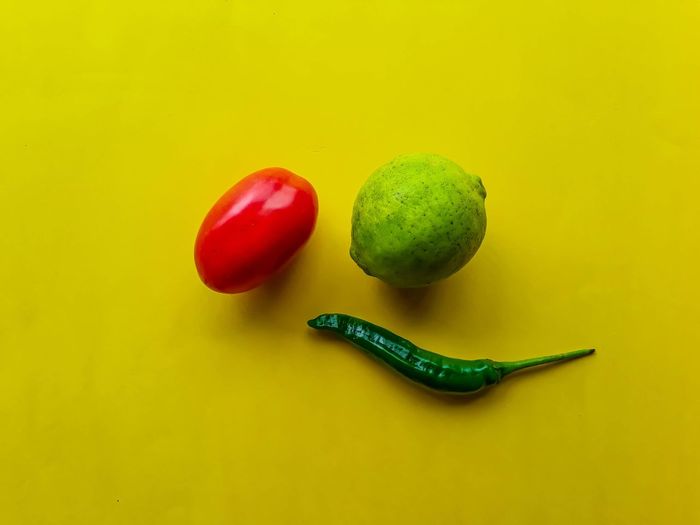Close-up of fruits against yellow background