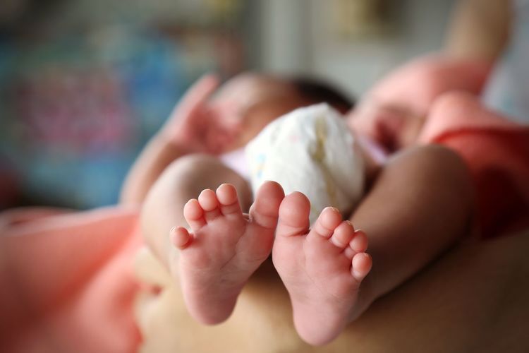 Close-up of baby lying on bed