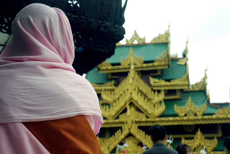 Rear view of woman in headscarf at temple