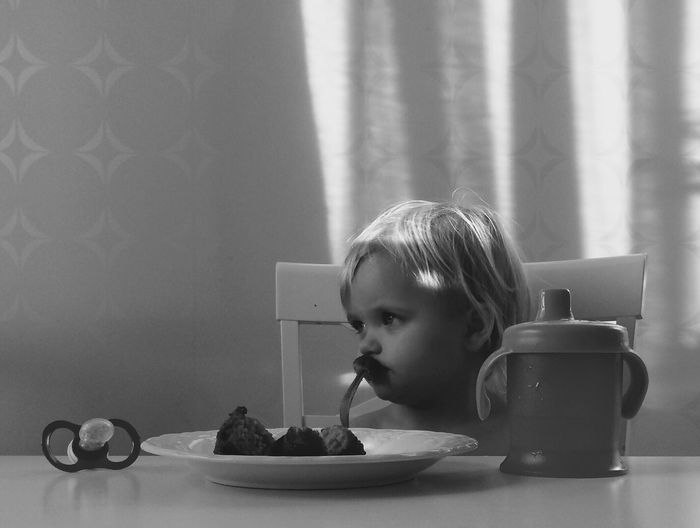 Thoughtful boy having food on table