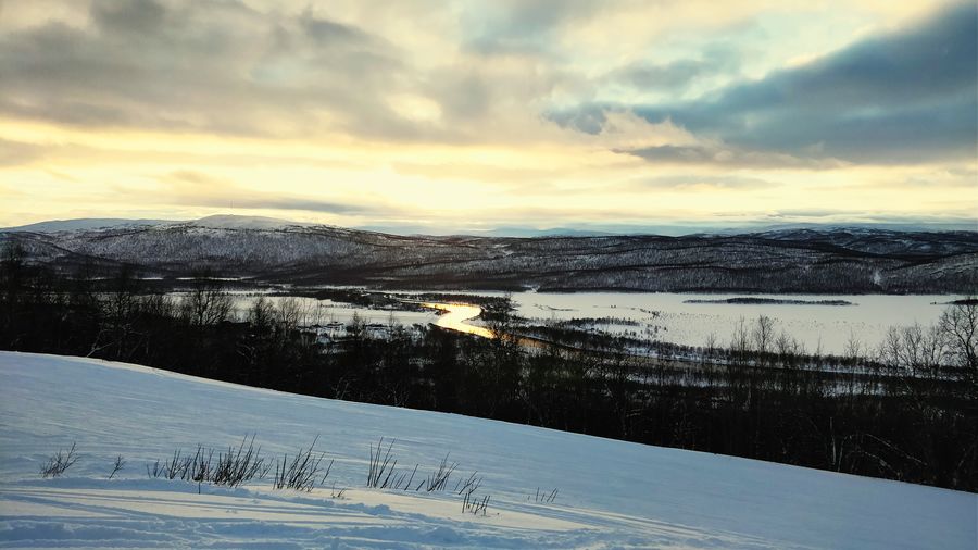 Scenic view of snow covered landscape against sky during sunset