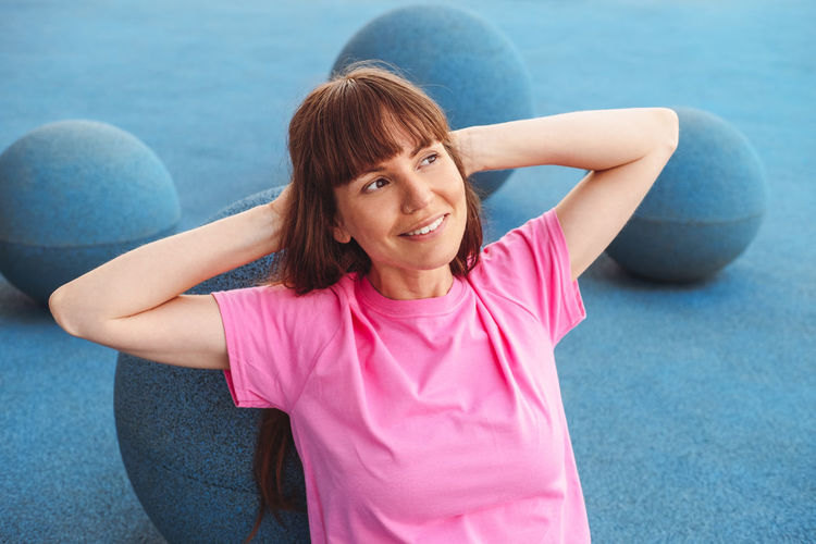 Portrait of women on blue background. woman wears pink t-shirt.
