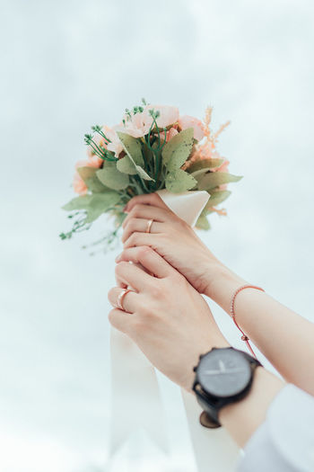Cropped hands of woman holding bouquet