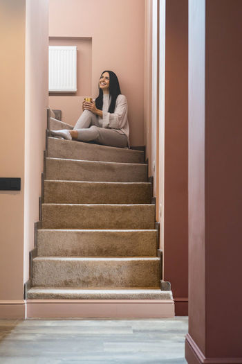 Rear view of woman sitting on staircase