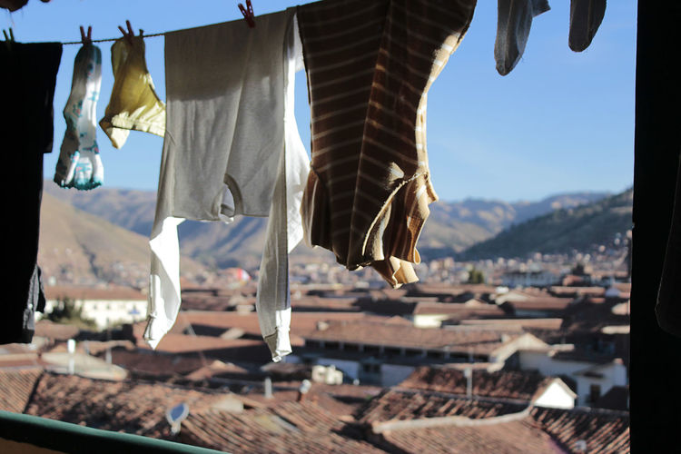 Close-up of clothes drying on roof against buildings
