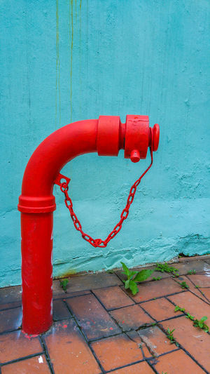 Fire hydrant by wall on footpath