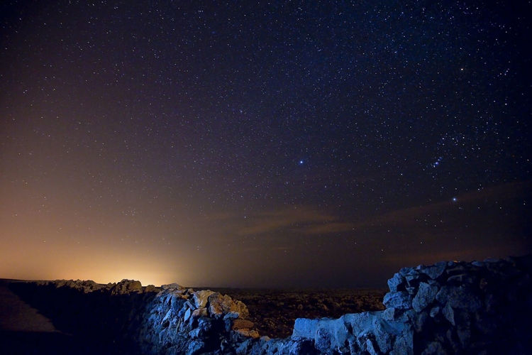 Scenic view of rock formation against sky at night