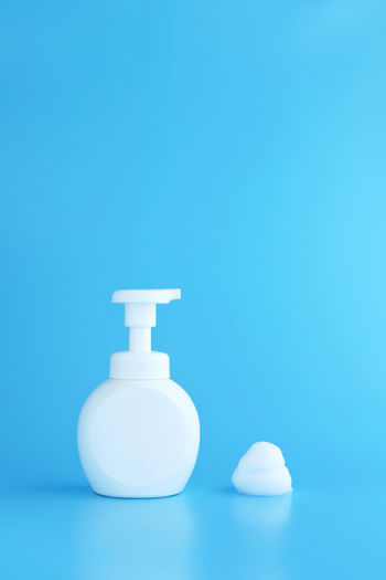 Close-up of white bottle against blue background