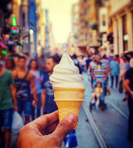 Close-up of hand holding ice cream cone on street