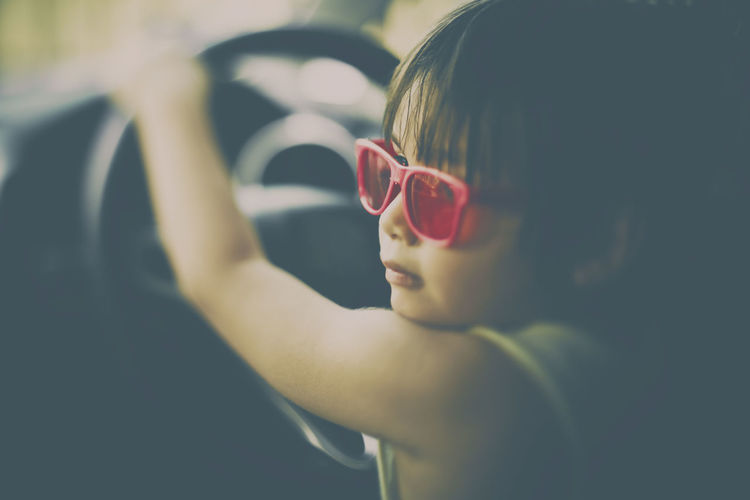 Close-up of child holding steering wheel