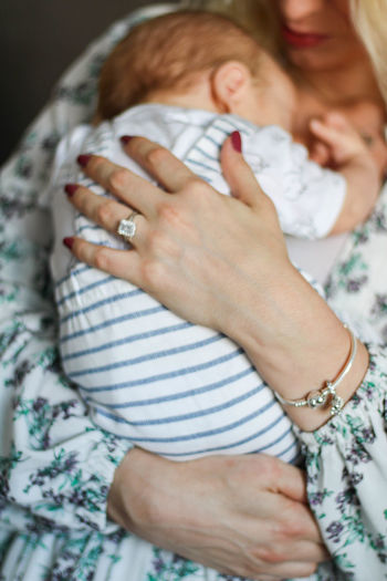 Midsection of woman with hands on baby