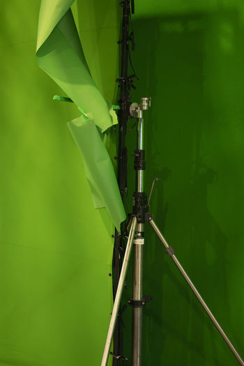 Close-up of metal pole against green wall