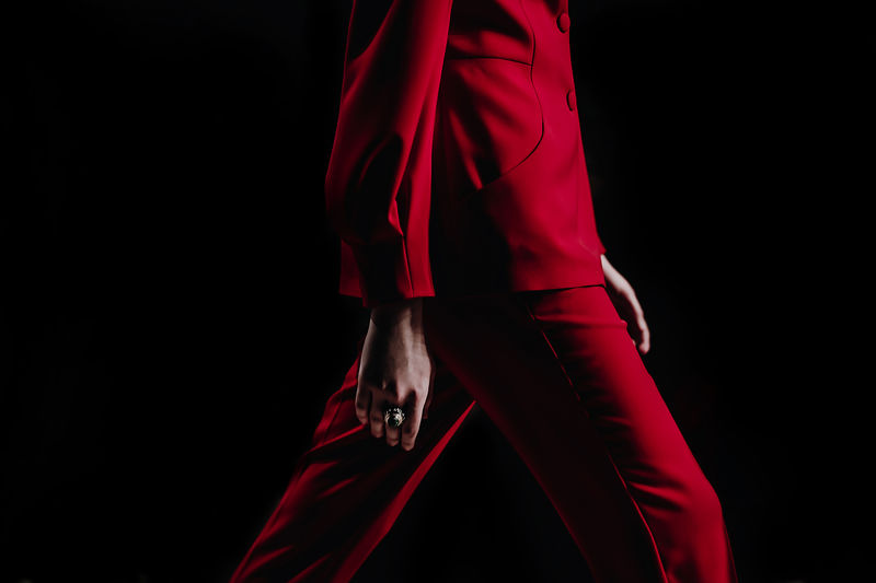 Close-up details of clothing on a woman model in red suit walks on the fashion show