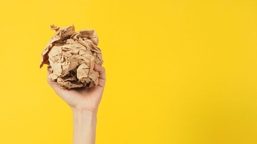 Close-up of human figurine against yellow background
