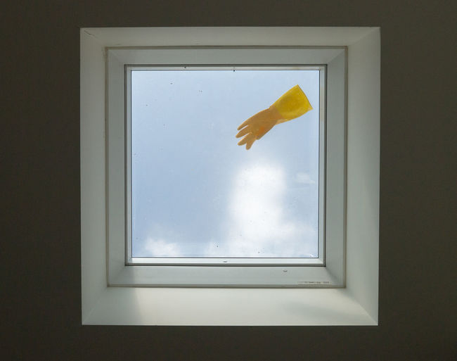 Yellow rubber glove on a skylight, shot from directly below