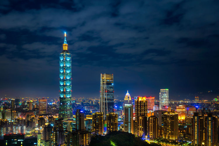 Illuminated buildings in city against sky at night. taipei.