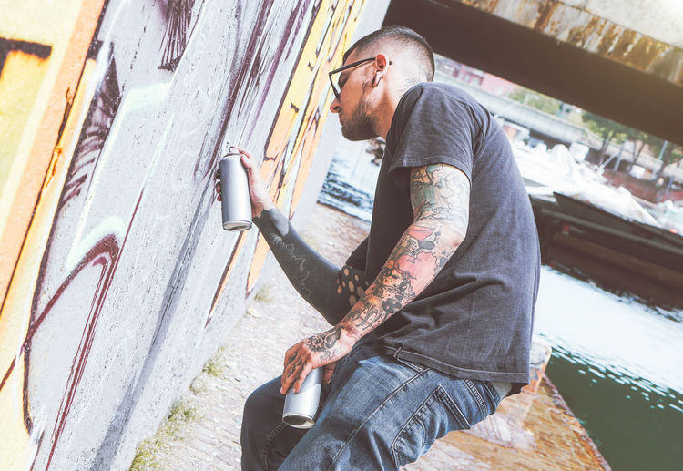 Man spraying paint on wall