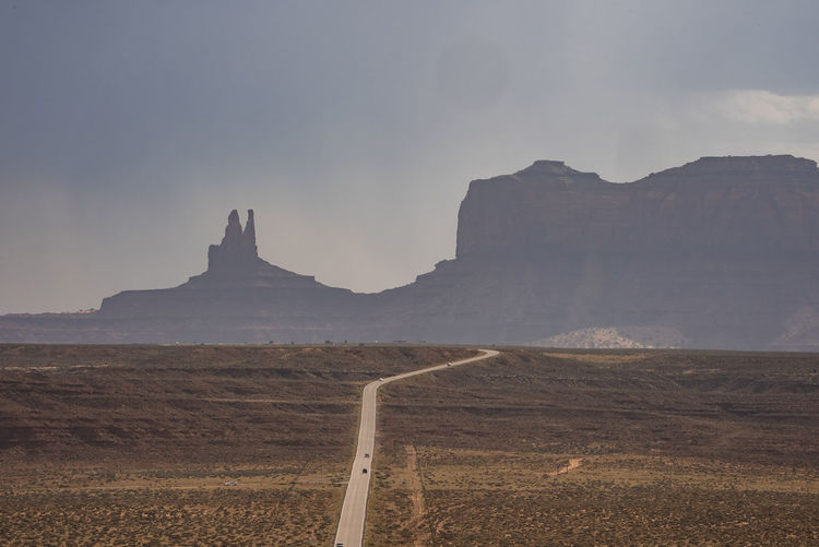 Aerial view of road leading towards monument valley with sky in background
