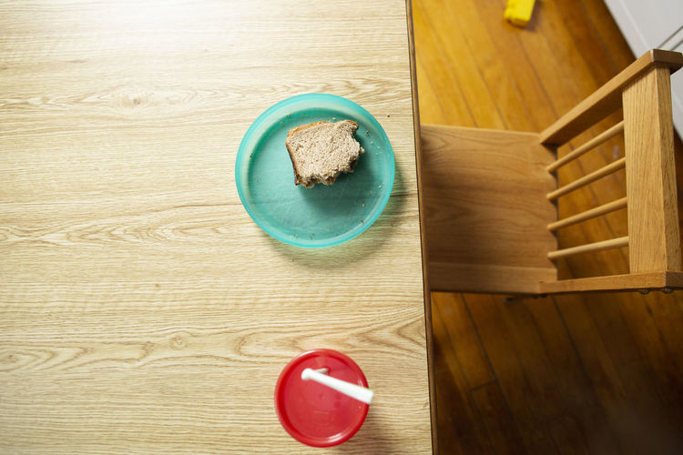 Peanut butter sandwich on colorful children's plate with empty chair