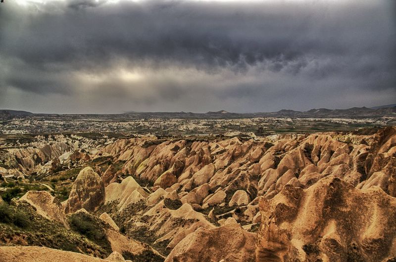 Scenic view of dramatic landscape against cloudy sky