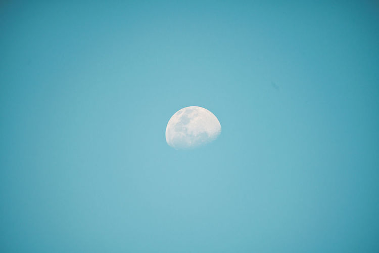 Low angle view of moon against blue sky at night