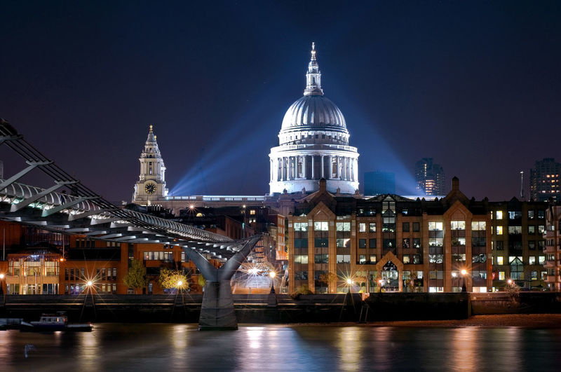 Illuminated buildings against sky at night