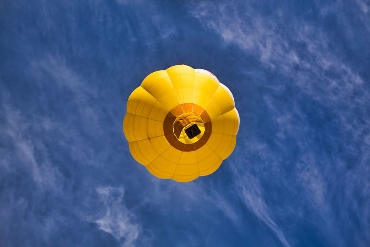 Low angle view of yellow balloons against sky