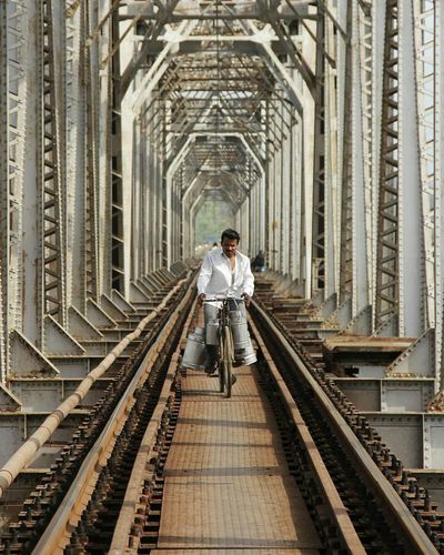 Man riding bike on bridge