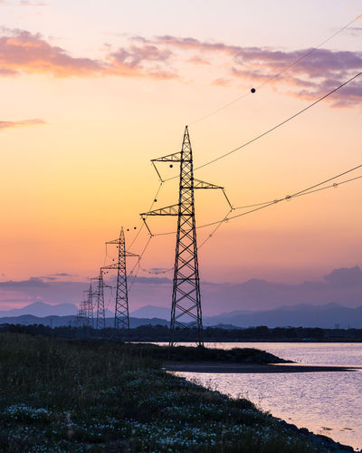 Power lines at sunset on lake