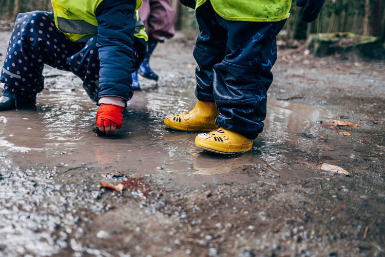 Lower section of children playing in puddle