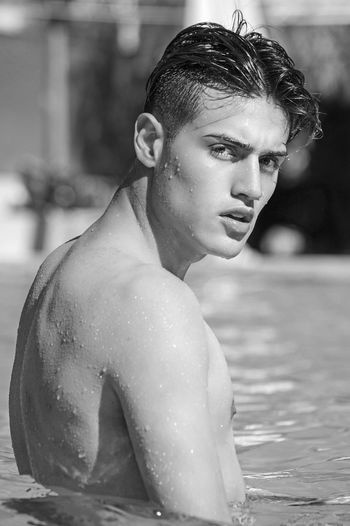 Portrait of shirtless teenage boy man in pool