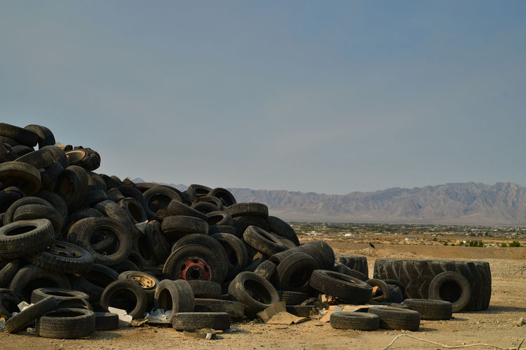 Worn-out vehicle tires piled in mojave desert with  distant mountains in pahrump, nevada, usa