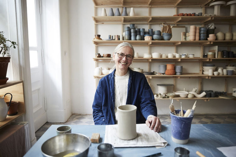 Portrait of smiling mature woman sitting in art class