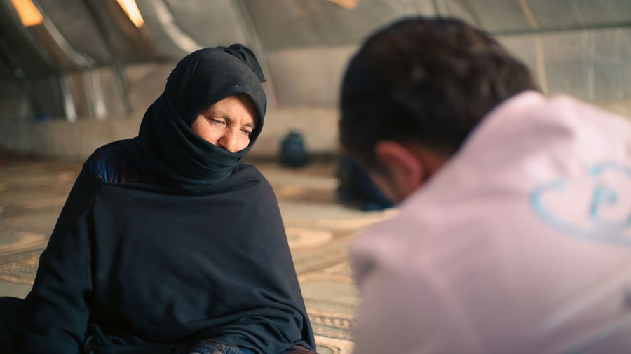 An elderly woman receives medical care at a makeshift medical clinic inside a syrian refugee camp.