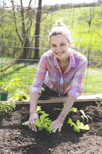 Smiling woman gardening in yard