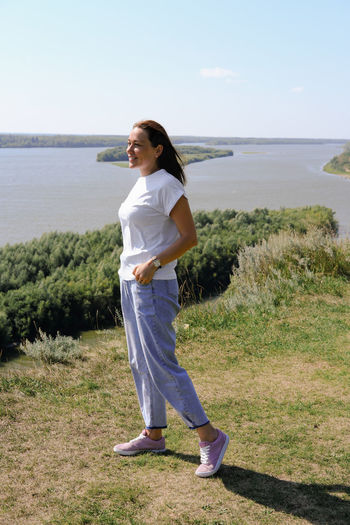Full length of woman standing on shore against sea