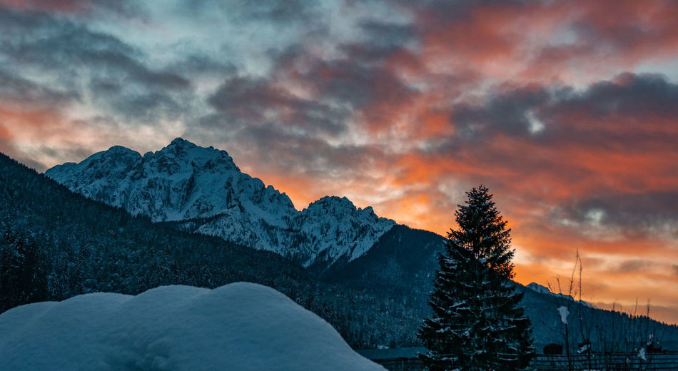 Orange sky and clouds above mountains. alpine landscape.