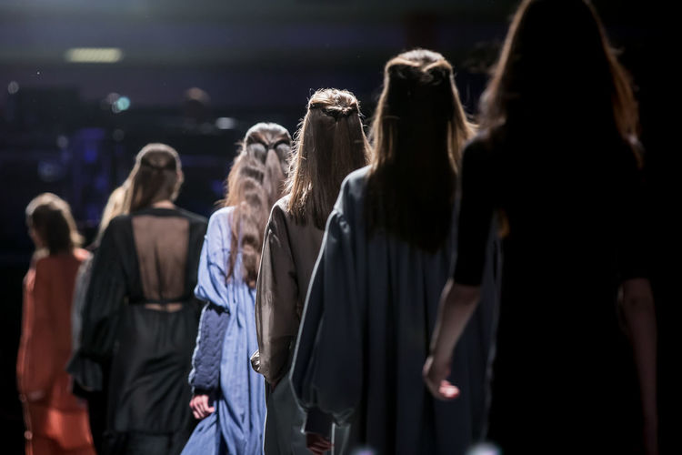 Rear view of models in row during fashion show