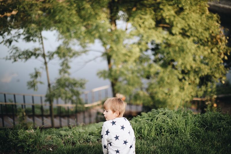 Rear view of boy standing at park