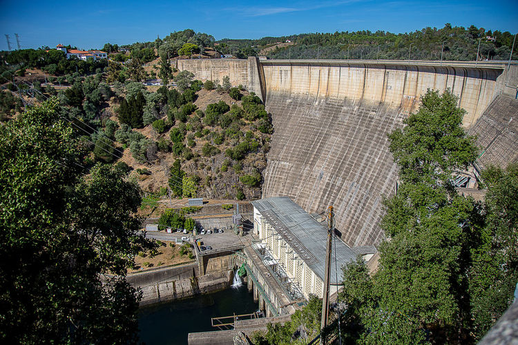 High angle view of dam by trees against sky
