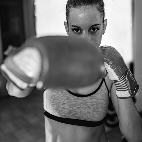 Portrait of female boxer boxing in gym
