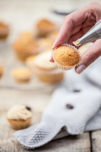 Cropped image of hand holding cupcake
