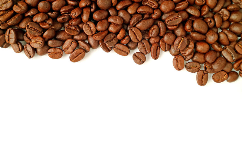 
heap of roasted coffee beans isolated on white background with copy space
