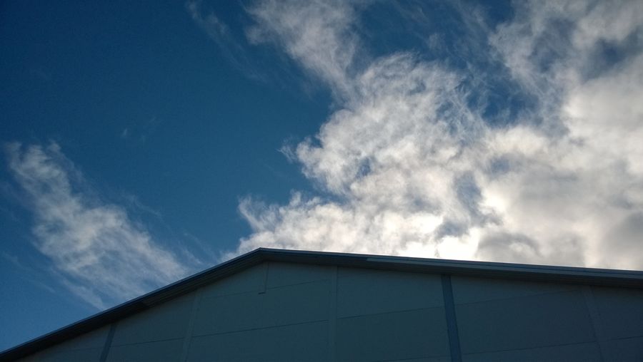 Low angle view of building against cloudy sky