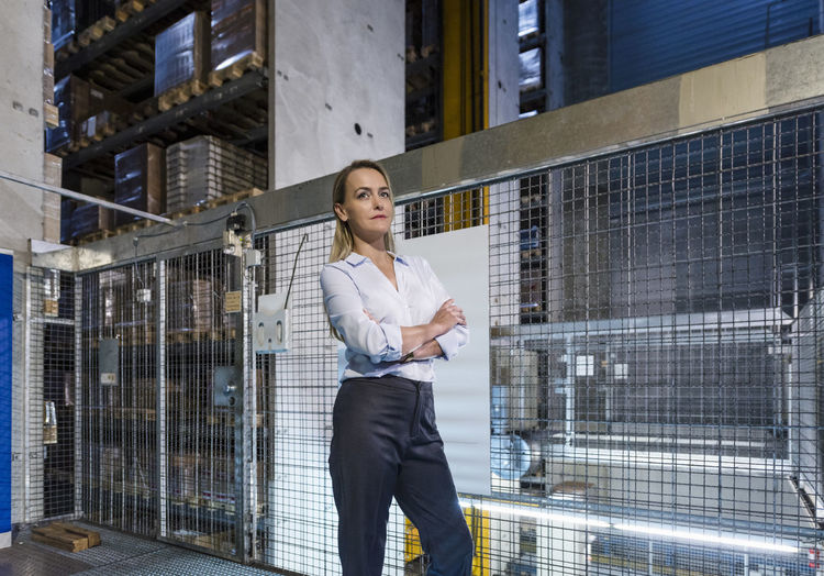 Blond woman in high rack warehouse