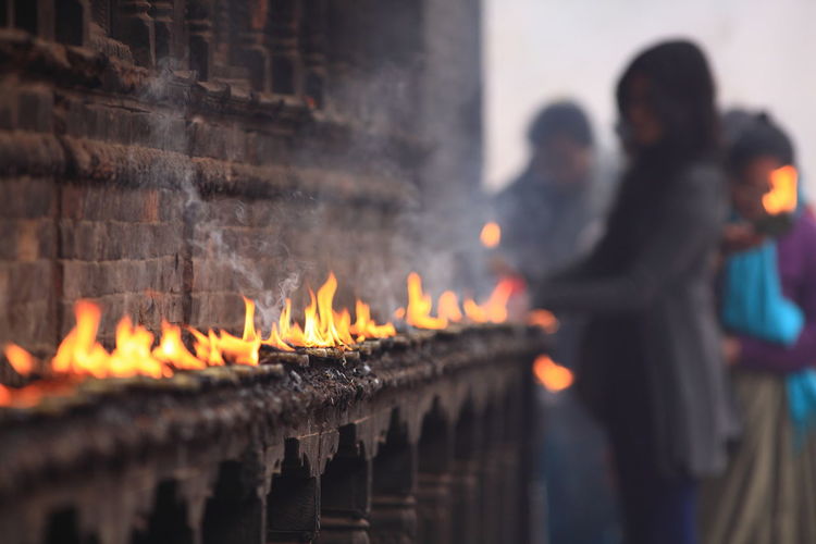 People burning candles at temple
