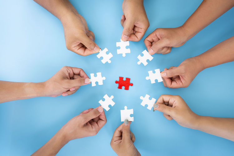 Cropped hands of person holding jigsaw piece