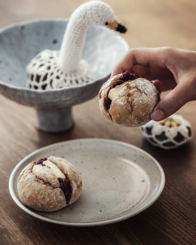 Midsection of person holding ice cream on table