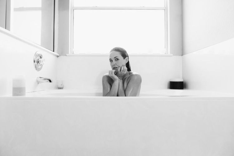 Woman sitting in bathtub